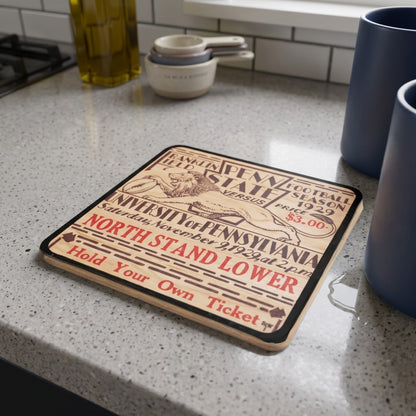 A rectangular wooden coaster with Row 1 trademark (Row One Brand) featuring a vintage University of Pennsylvania 1929 ticket design, displayed on a speckled kitchen countertop.