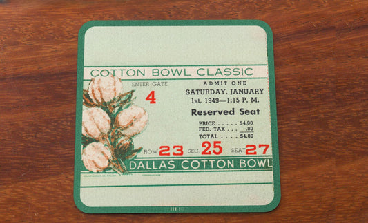 Vintage ticket coasters for the Cotton Bowl Classic on a wooden surface