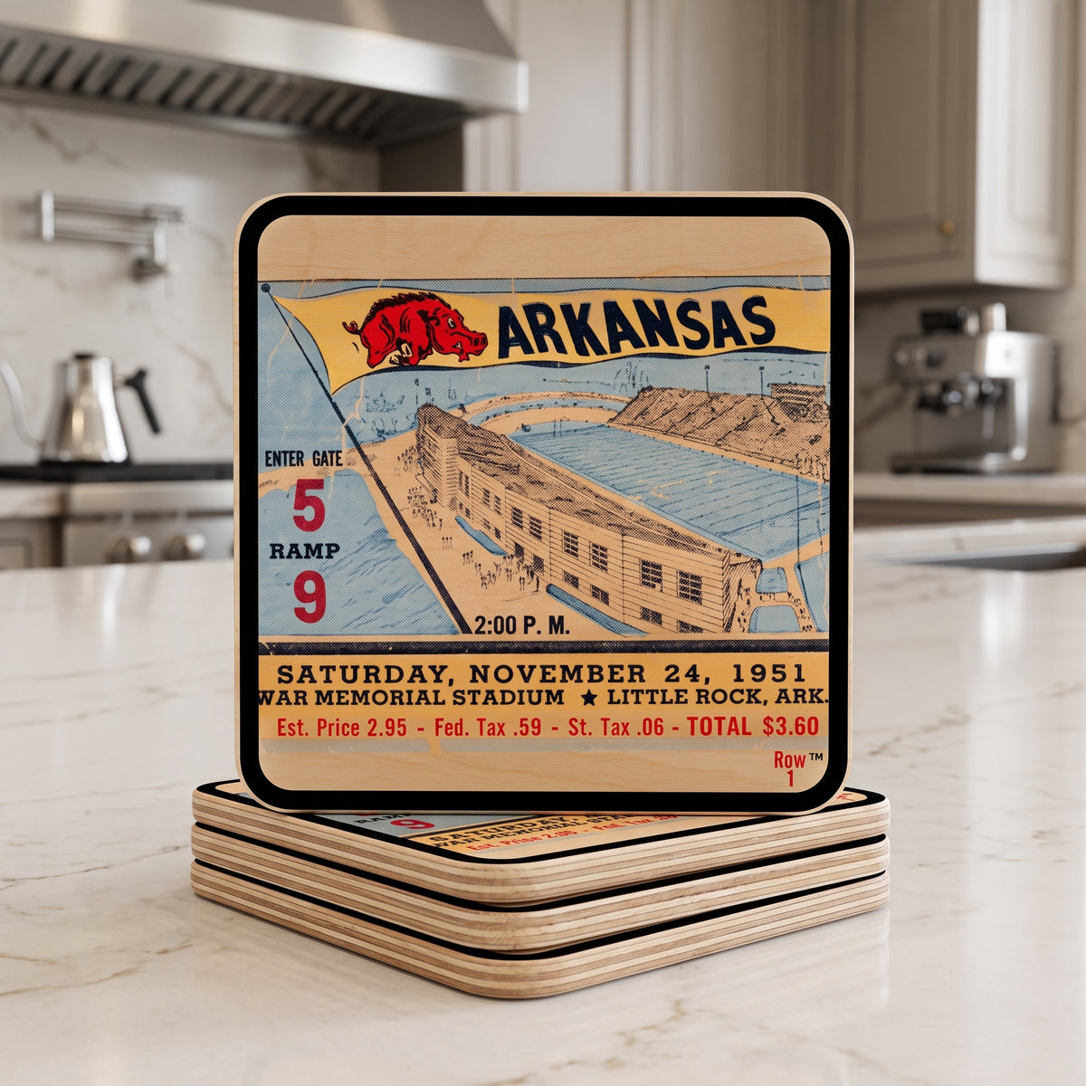 A square birch wood historic 1951 Arkansas football ticket coaster set displayed upright on a stack of matching coasters on a kitchen countertop. Row 1 trademark clearly visible in lower right corner.