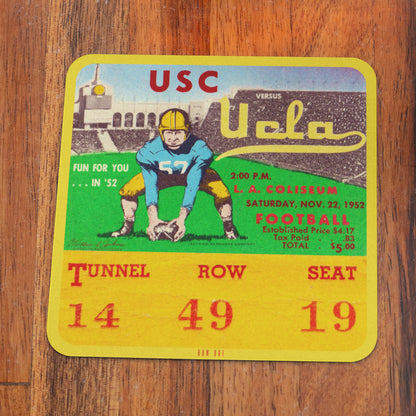 Vintage USC vs UCLA football ticket stub on a wooden surface