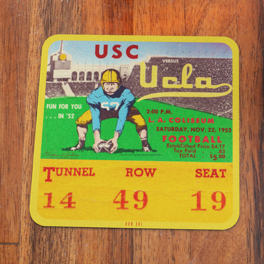 Vintage USC vs UCLA football ticket stub on a wooden surface