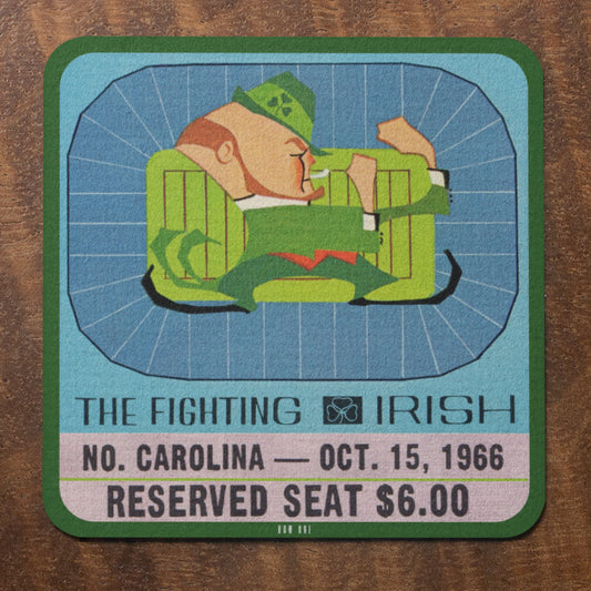 Historic Notre Dame vs. North Carolina 1966 Vintage ticket coaster with a graphic of a person in a green outfit and hat, on a wooden surface.
