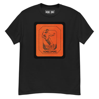 A black short-sleeve crewneck t-shirt featuring a large orange graphic print on the front with a silhouette of a football player and the word 'HOMECOMING'. The inside collar shows a white label with the brand 'ROW ONE'.