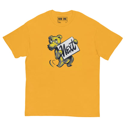 A yellow crewneck t-shirt featuring a cartoon bear mascot holding a sign that reads 'Next' in script. The brand 'ROW ONE' is printed inside the collar.