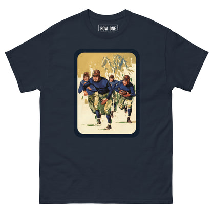 A navy blue crewneck t-shirt featuring a vintage-style graphic print of football players running with a football on a cream-colored background, framed by a dark border. The brand 'ROW ONE' is printed inside the collar.