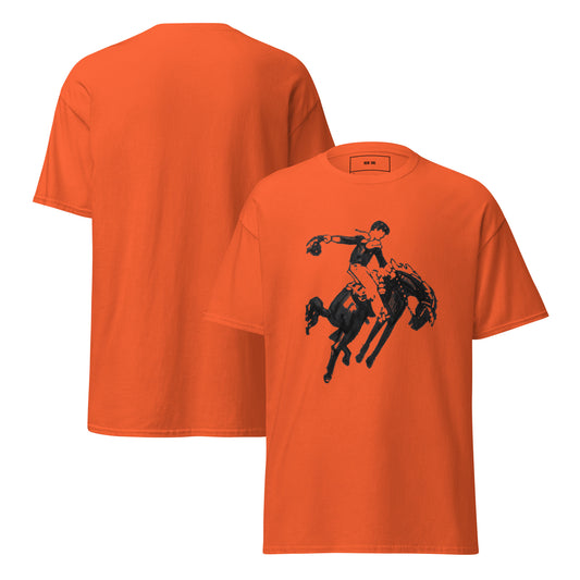 Bright orange Row One Brand short-sleeve t-shirt shown from both front and back. The front features a black graphic print of a cowboy riding a bucking horse, while the back is solid orange with Row One trademark inside label.