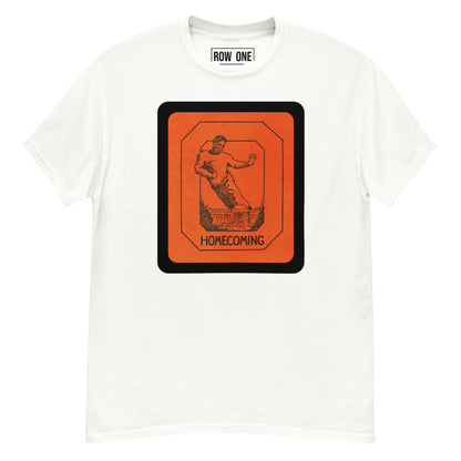 A white crewneck t-shirt featuring a large orange and black graphic print on the front with the text 'HOMECOMING' and an illustration of a football player. The inside collar shows the brand label 'ROW ONE'.