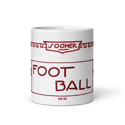 A white ceramic mug featuring a red graphic print styled like a vintage football ticket with the text 'SOONER FOOTBALL' and 'ROW ONE'.